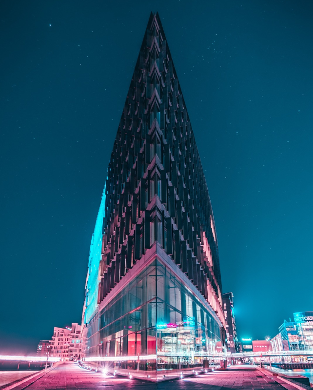 skyscraper building against night sky with neon pink lights