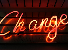 orange neon light reading 'change' against black background
