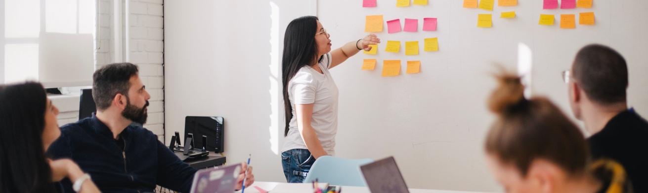 team of people in meeting brainstorming with post it notes