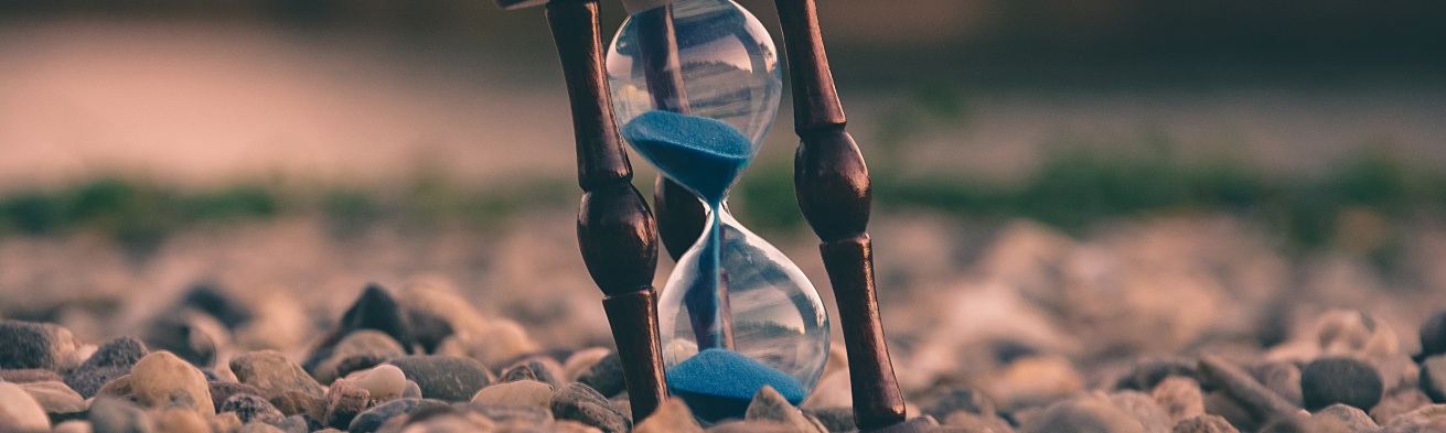 hour glass sand timer sitting on rocks