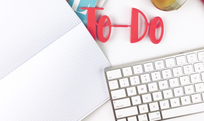 blank notebook and mac keyboard with red letters reading "to-do"