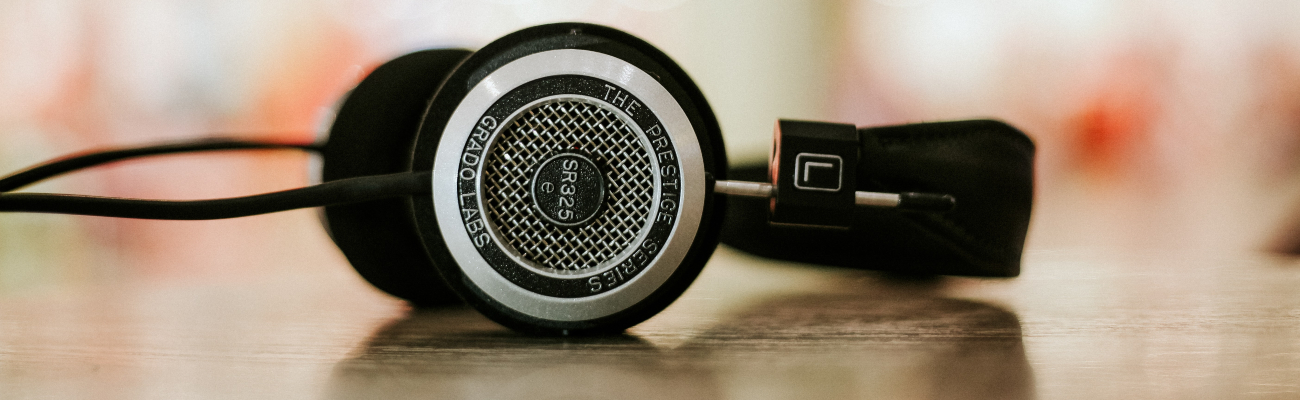 Close up of old style headphones lying on a wooden table