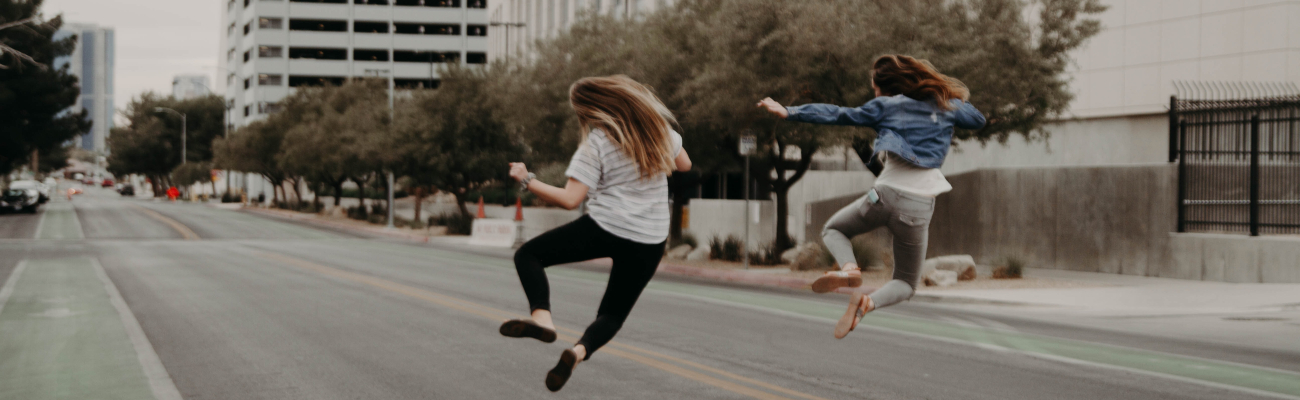 Empty city street scene with two men jumping for joy